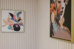 Zwei moderne Gemälde schmücken die Wand über einem gemütlichen grauen Sofa, das in einem stilvollen Raum steht.