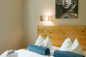 Ein stilvolles Schlafzimmer mit einem beruhigenden Gemälde und sorgfältig arrangierten Kissen lädt zur Entspannung ein.