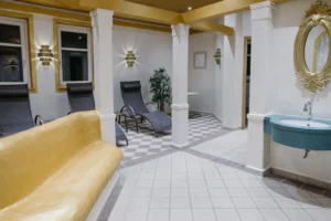 Ein eleganter, ruhiger Loungebereich mit Liegestühlen und goldenen Akzenten lädt zur Entspannung in luxuriöser Atmosphäre ein.