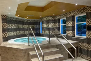 Ein stilvoller Innenraum mit Whirlpool und Mosaikwänden lädt zur Entspannung und Erholung ein.