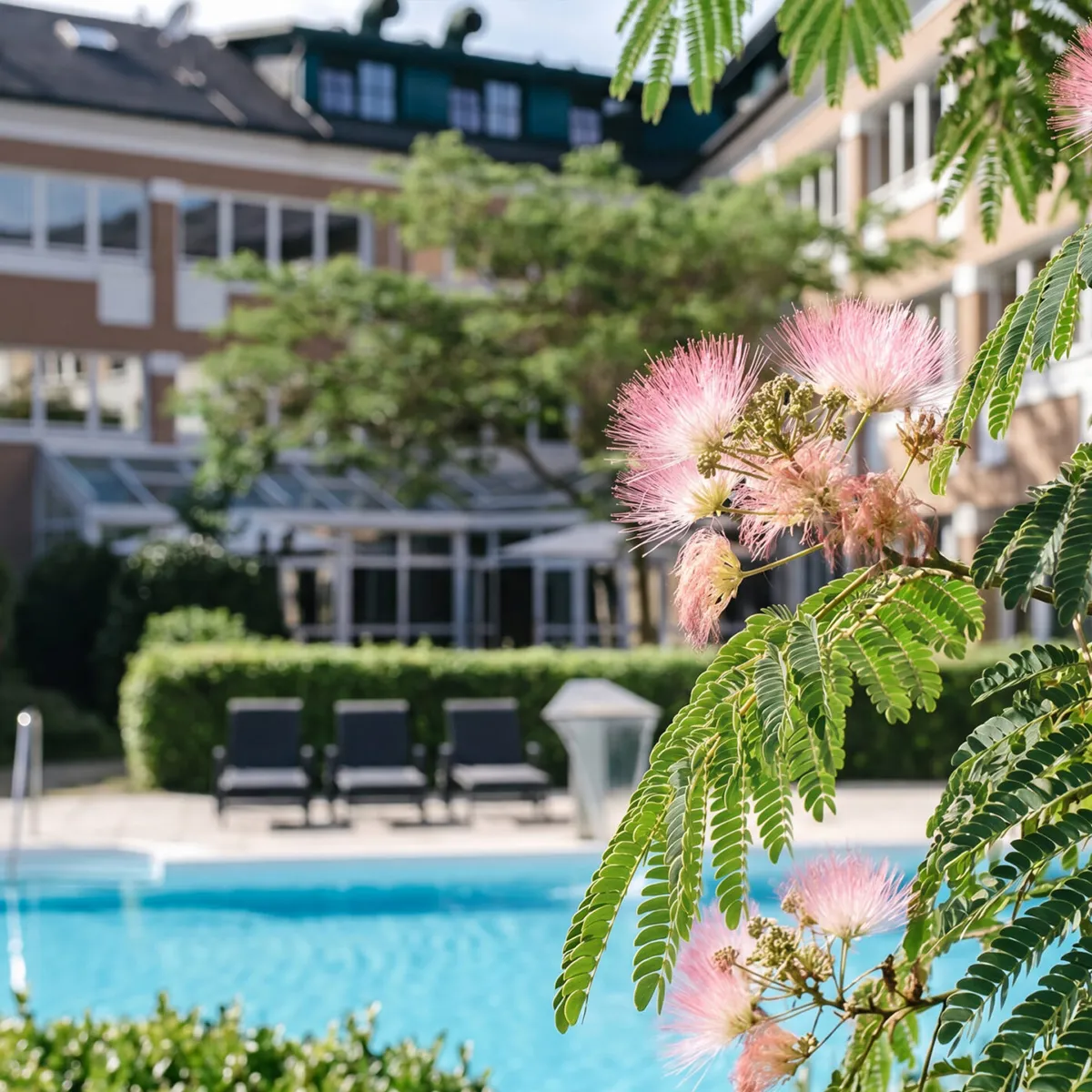 Blühende Pflanzen umgeben einen ruhigen Poolbereich, ideal für dein Sommer-Retreat. | © YOGALIFE Graz