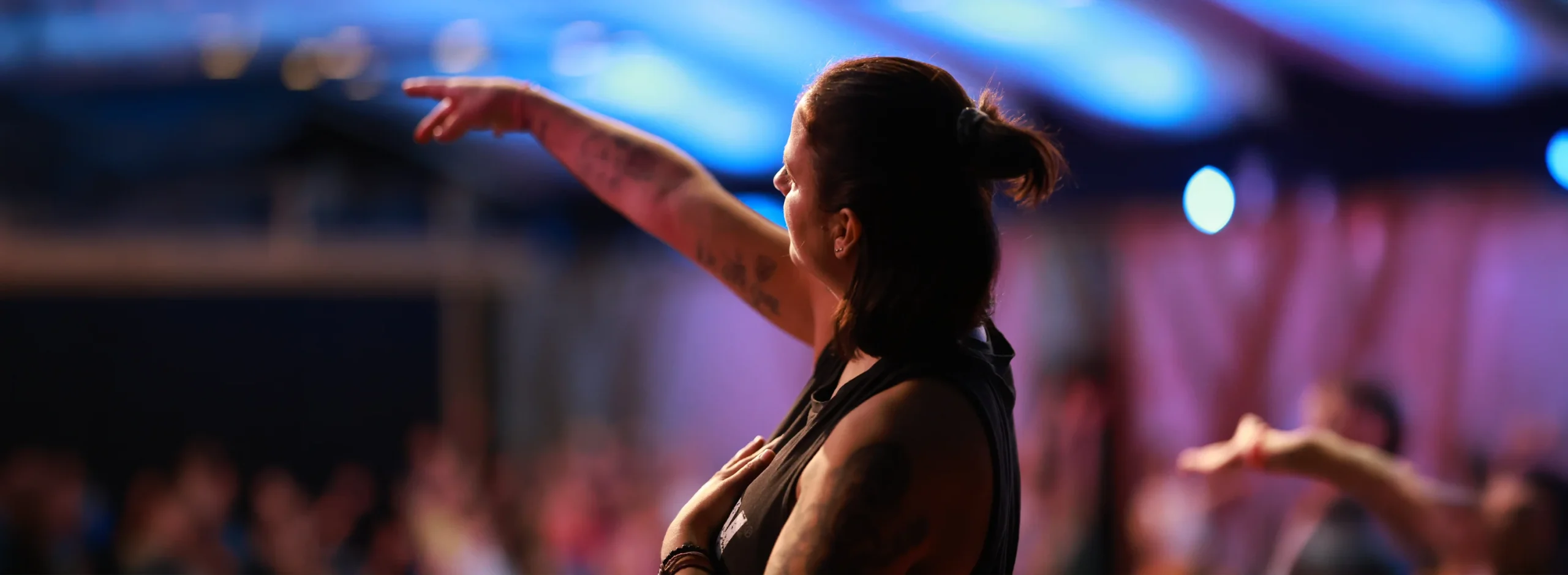 Eine yogalehrende Person leitet eine Gruppe von Teilnehmern an, um harmonische Bewegungen im Inside Flow zu üben.